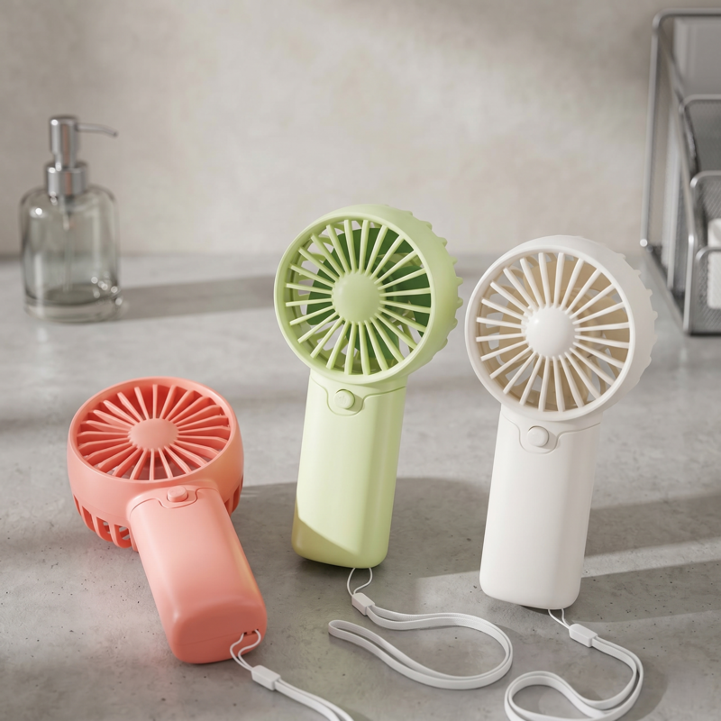 Group of three Retailark lightweight AA battery pocket fans in various colors standing on a bathroom counter.